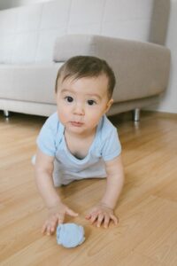 Baby crawling on wooden floor